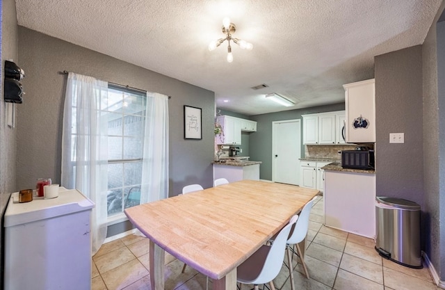 tiled dining room with a textured ceiling