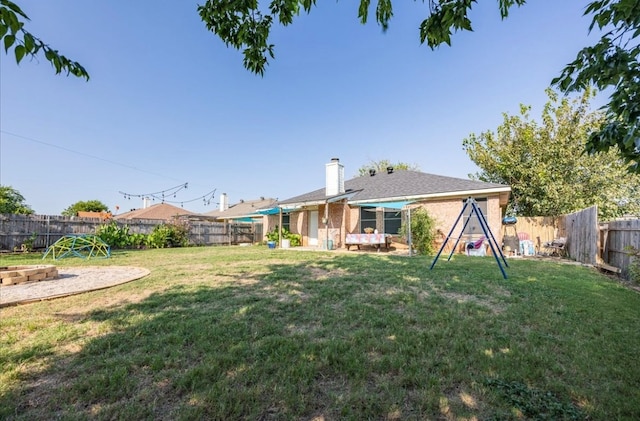 rear view of property featuring a lawn and a patio area