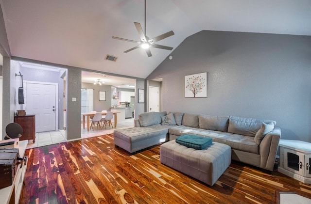 living room with high vaulted ceiling, ceiling fan, and dark wood-type flooring