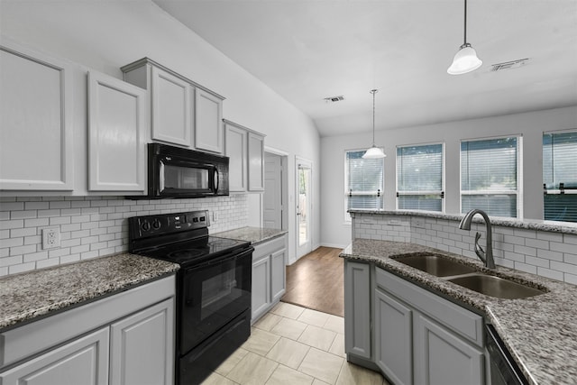 kitchen featuring backsplash, decorative light fixtures, black appliances, and sink