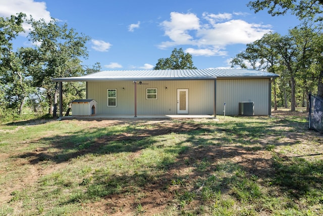 rear view of property featuring a yard, a shed, and a patio area