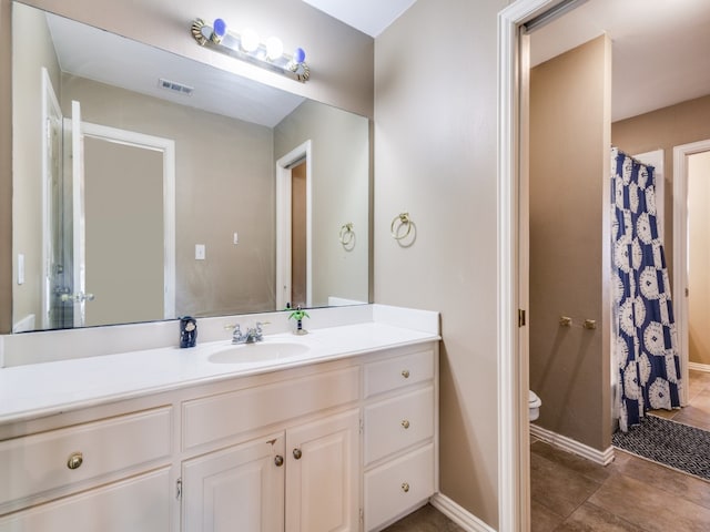 bathroom featuring tile patterned flooring, vanity, and toilet