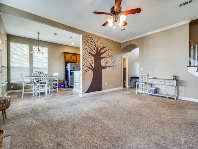 unfurnished living room with ornamental molding, carpet, and ceiling fan