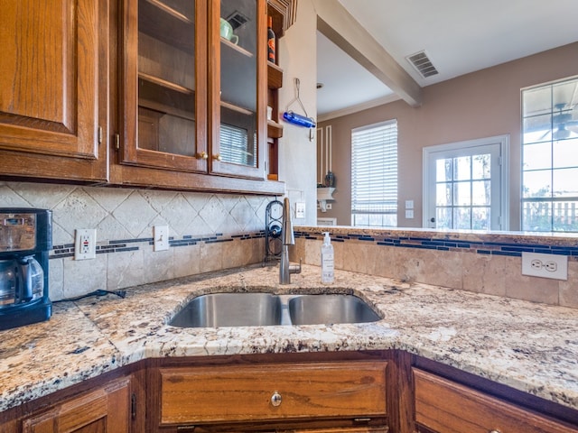 kitchen featuring crown molding, sink, and tasteful backsplash