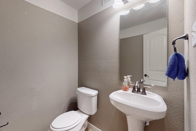 2924 Peyton Brook Dr, Fort Worth, TX 76137 - half bathroom featuring toilet, a textured wall, and a sink