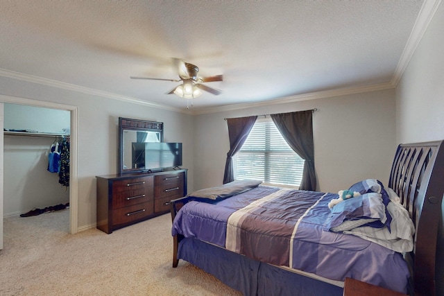 carpeted bedroom featuring a textured ceiling, a closet, ceiling fan, and crown molding