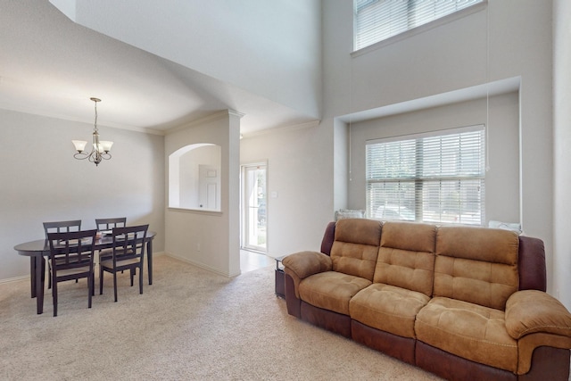 carpeted living room featuring crown molding and a notable chandelier