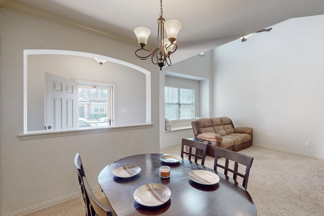 carpeted dining area featuring lofted ceiling, an inviting chandelier, and crown molding