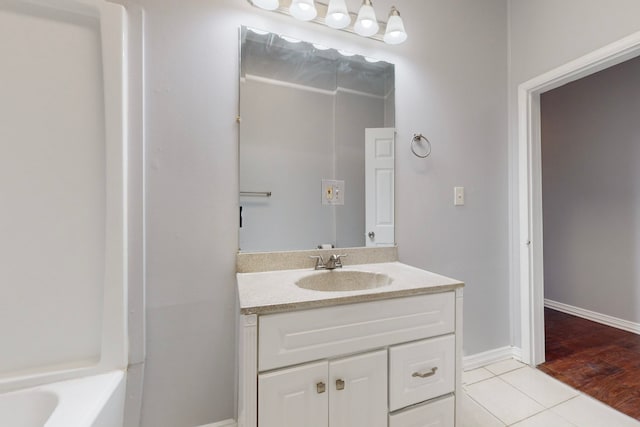 bathroom with a tub to relax in, hardwood / wood-style flooring, and vanity