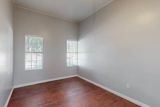 spare room with ornamental molding, a healthy amount of sunlight, and dark hardwood / wood-style flooring