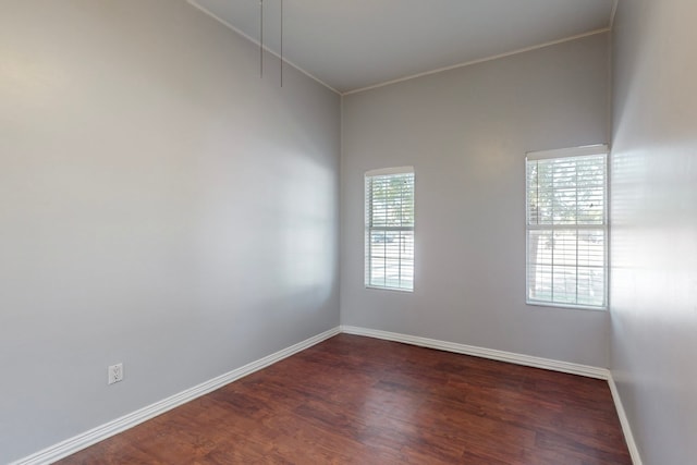 unfurnished room with crown molding and dark wood-type flooring