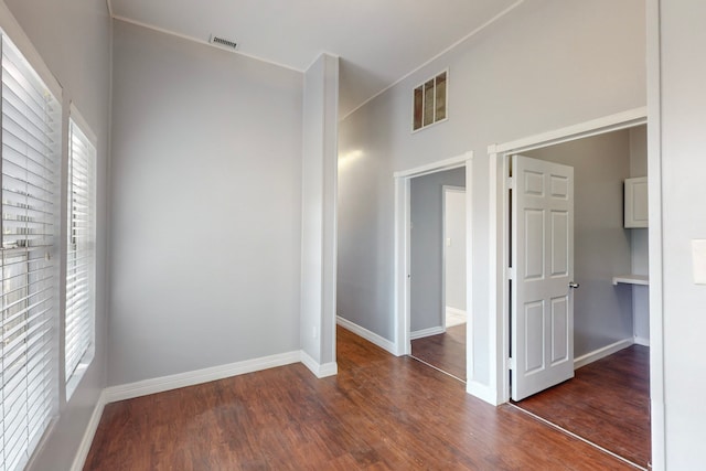 spare room with plenty of natural light and dark hardwood / wood-style flooring