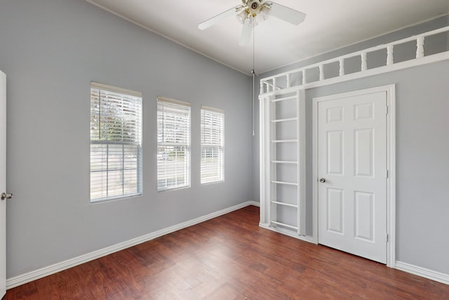 empty room with dark wood-type flooring and ceiling fan