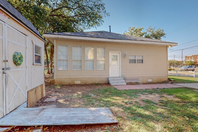 rear view of house with a storage shed