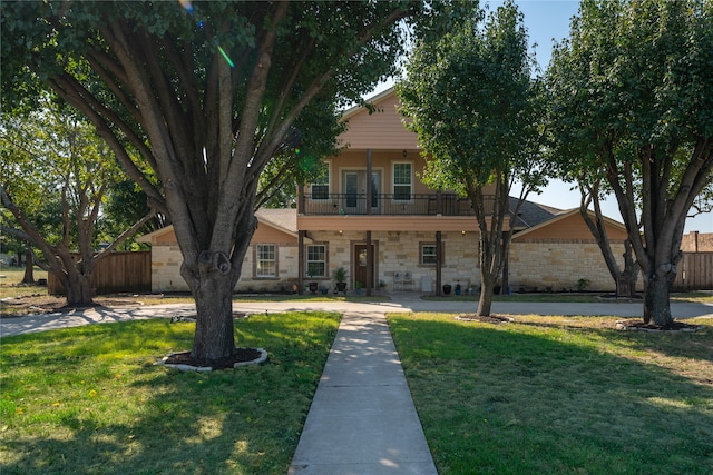 view of front of home with a front yard and a balcony