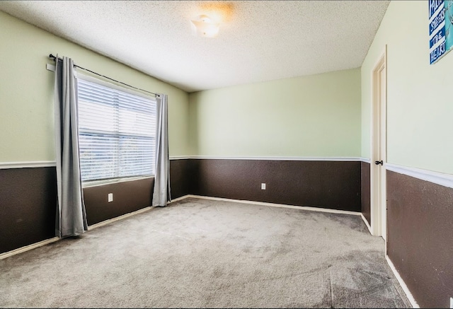 carpeted empty room featuring a textured ceiling