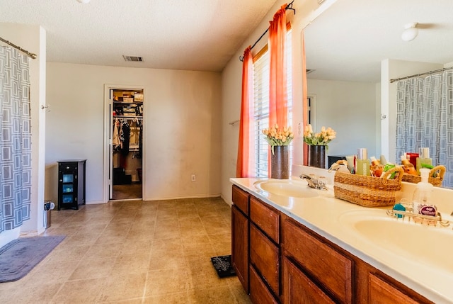 bathroom featuring vanity, a textured ceiling, and tile patterned floors