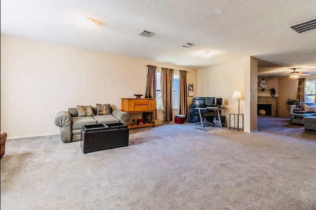 living room featuring a fireplace, a textured ceiling, carpet, and ceiling fan