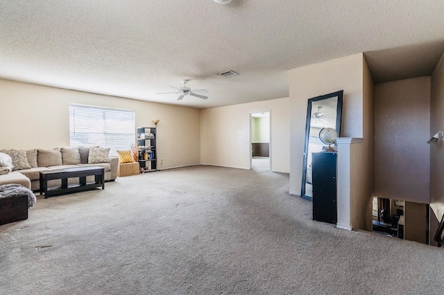 carpeted living room with a textured ceiling and ceiling fan