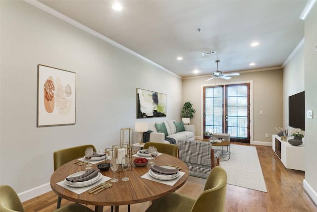 dining area with light hardwood / wood-style flooring, ornamental molding, and ceiling fan