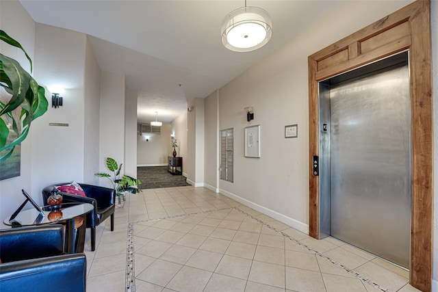 hall featuring light tile patterned flooring and elevator