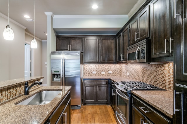 kitchen with light stone counters, ornamental molding, sink, light hardwood / wood-style flooring, and appliances with stainless steel finishes