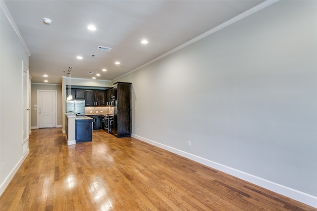 unfurnished living room featuring ornamental molding and light hardwood / wood-style flooring