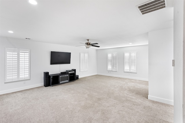 unfurnished living room with light colored carpet and ceiling fan