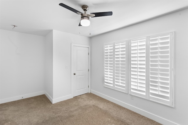 empty room featuring light carpet and ceiling fan