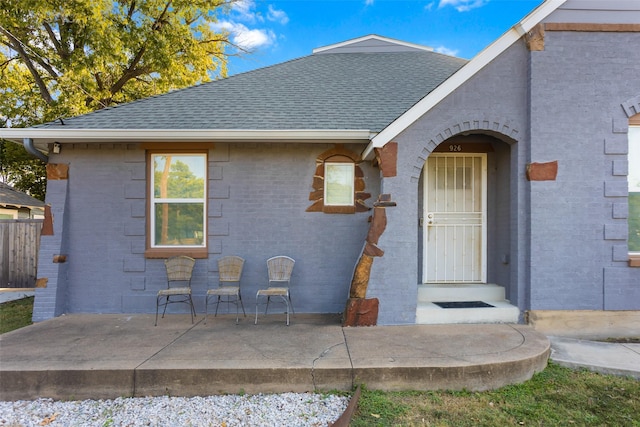 926 S Waverly Dr, Dallas, TX 75208 - view of exterior entry with roof with shingles, brick siding, and a patio