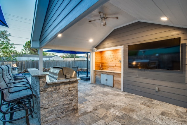 view of patio / terrace with exterior kitchen, a grill, and ceiling fan