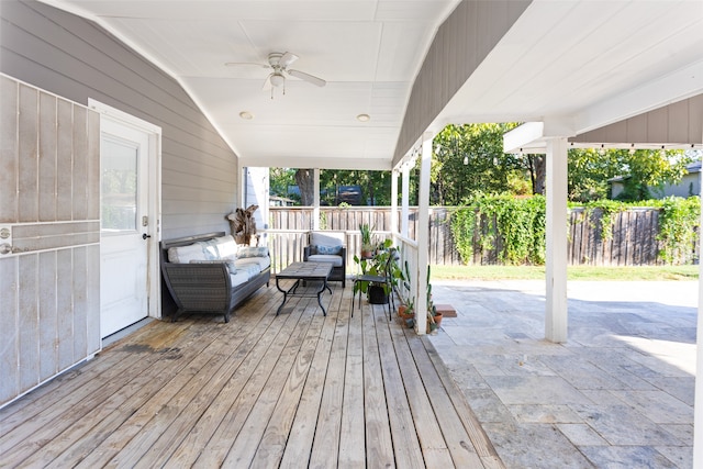 wooden terrace featuring ceiling fan, a patio area, and an outdoor living space