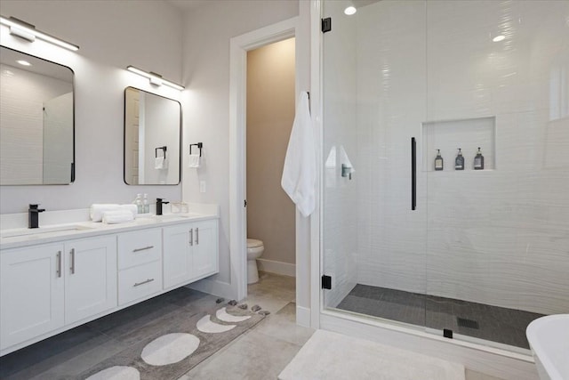 2604 Flora Ln, Denison, TX 75020 - full bathroom featuring a stall shower, toilet, double vanity, and baseboards