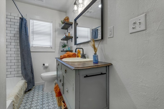 full bathroom featuring a wealth of natural light, vanity, toilet, and shower / bath combo