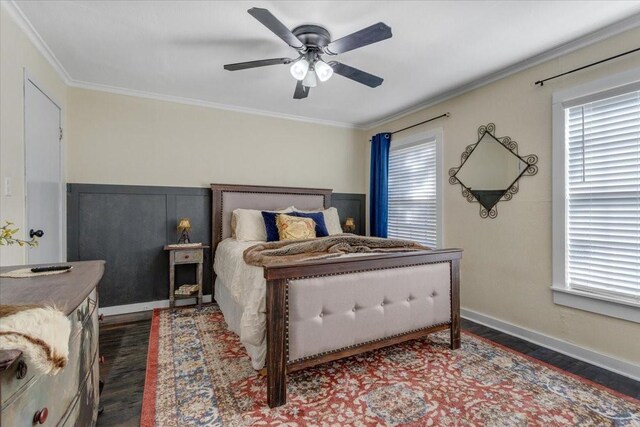 bedroom with dark hardwood / wood-style flooring, ceiling fan, and crown molding