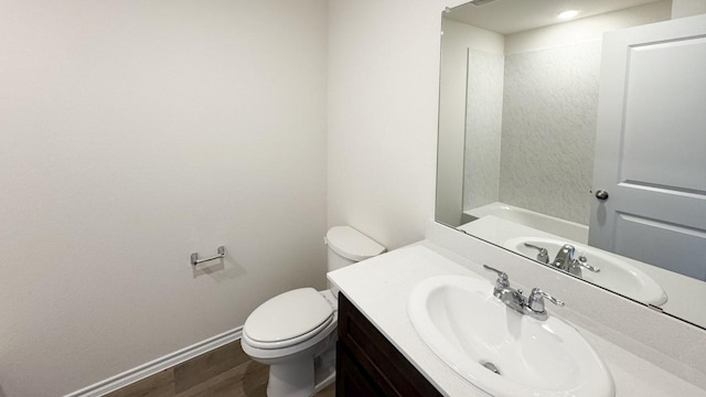 bathroom featuring toilet, vanity, and hardwood / wood-style flooring