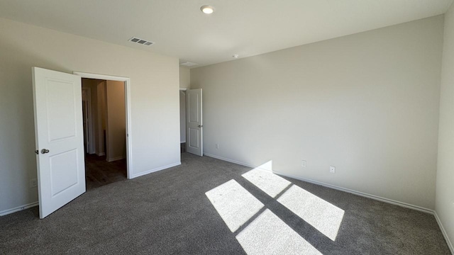 unfurnished bedroom with dark carpet