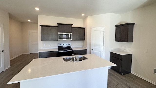 kitchen featuring a kitchen island with sink, sink, stainless steel appliances, and dark hardwood / wood-style floors