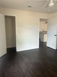 spare room featuring dark wood-type flooring and ceiling fan