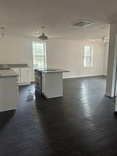 kitchen featuring white cabinets, a wealth of natural light, dark hardwood / wood-style floors, and a center island