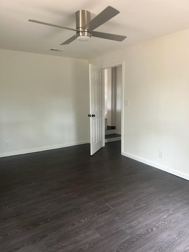 spare room featuring dark wood-type flooring and ceiling fan