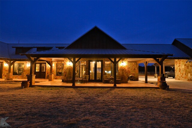 back house at twilight featuring a patio area