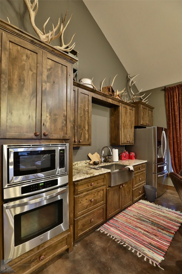 kitchen with light stone counters, sink, and stainless steel appliances