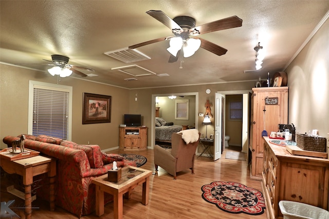 living room featuring ceiling fan, sink, light wood-type flooring, and a textured ceiling