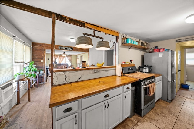 kitchen with butcher block counters, a healthy amount of sunlight, and appliances with stainless steel finishes