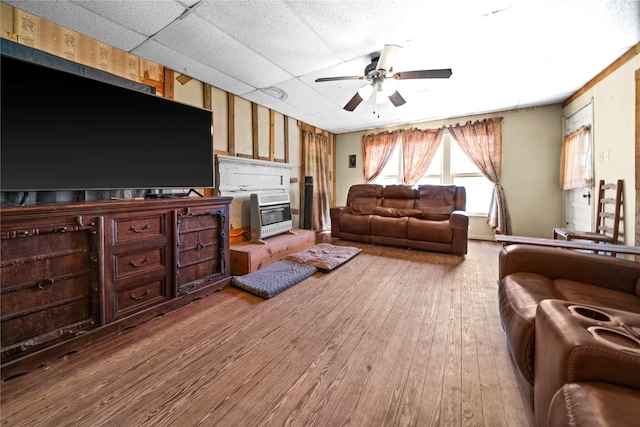 living room featuring ceiling fan, a drop ceiling, and hardwood / wood-style floors