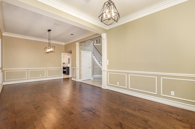 unfurnished room featuring dark hardwood / wood-style floors, crown molding, and a chandelier