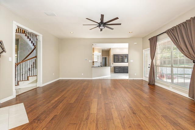 unfurnished living room featuring ceiling fan and wood-type flooring