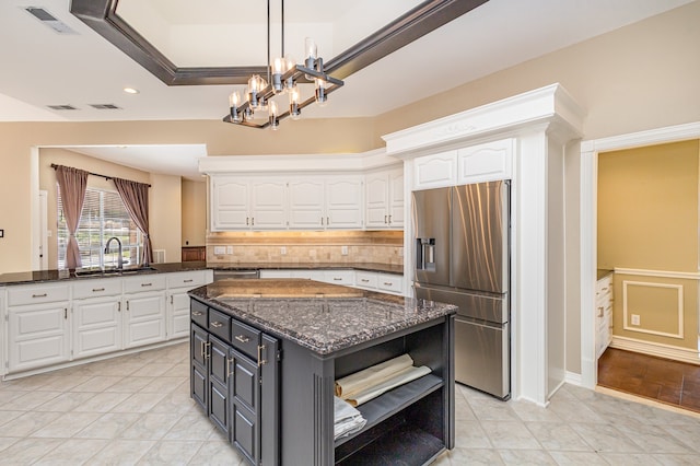 kitchen featuring stainless steel fridge, sink, and white cabinets