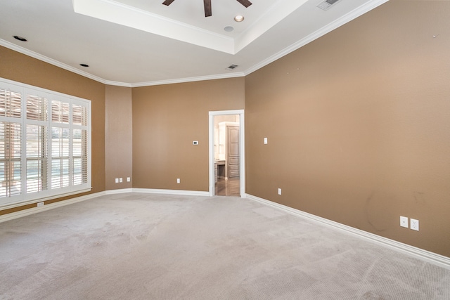 empty room featuring ceiling fan, light colored carpet, and ornamental molding